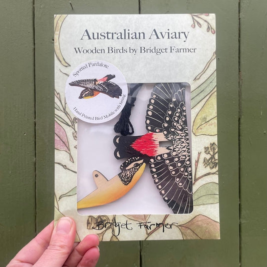 Product packaging of 'Australian Aviary' wooden birds by Bridget Farmer on a green background.