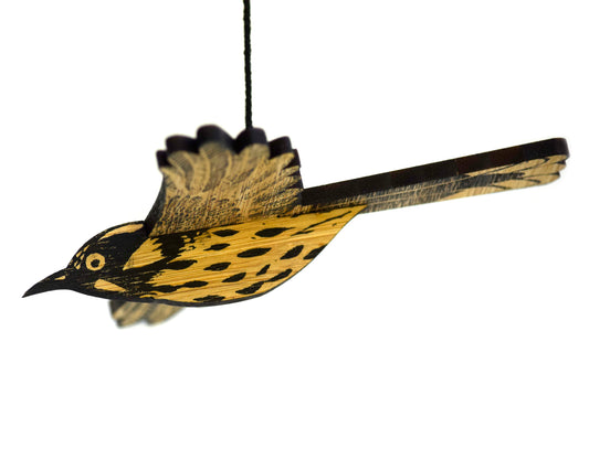 A mobile depicting a new holland honeyeater bird with black, yellow, and white patterns, made from layered plywood.